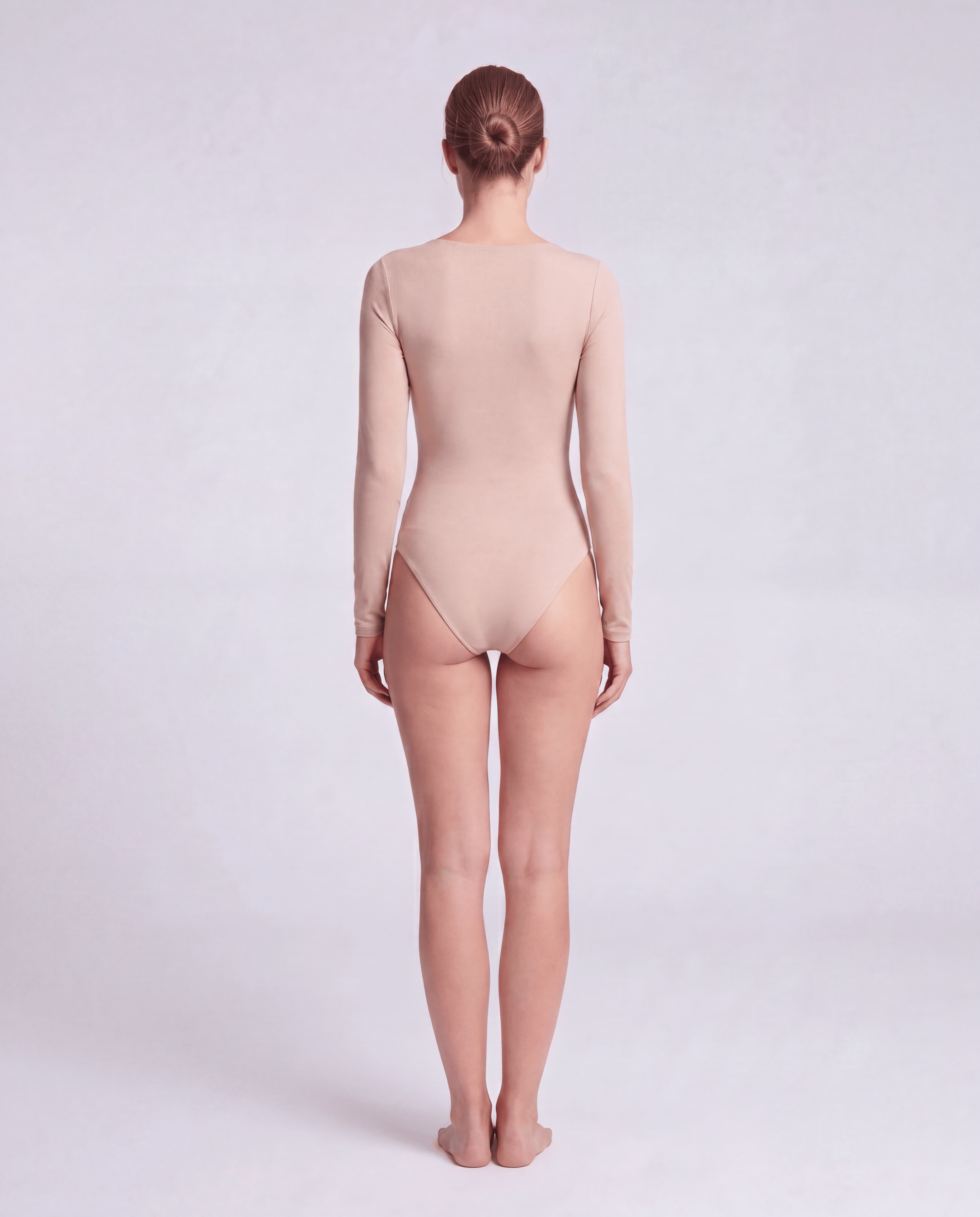 Black V-neck long sleeve bodysuit by ROMAR, fitted style with seamless fabric, shown on a model.