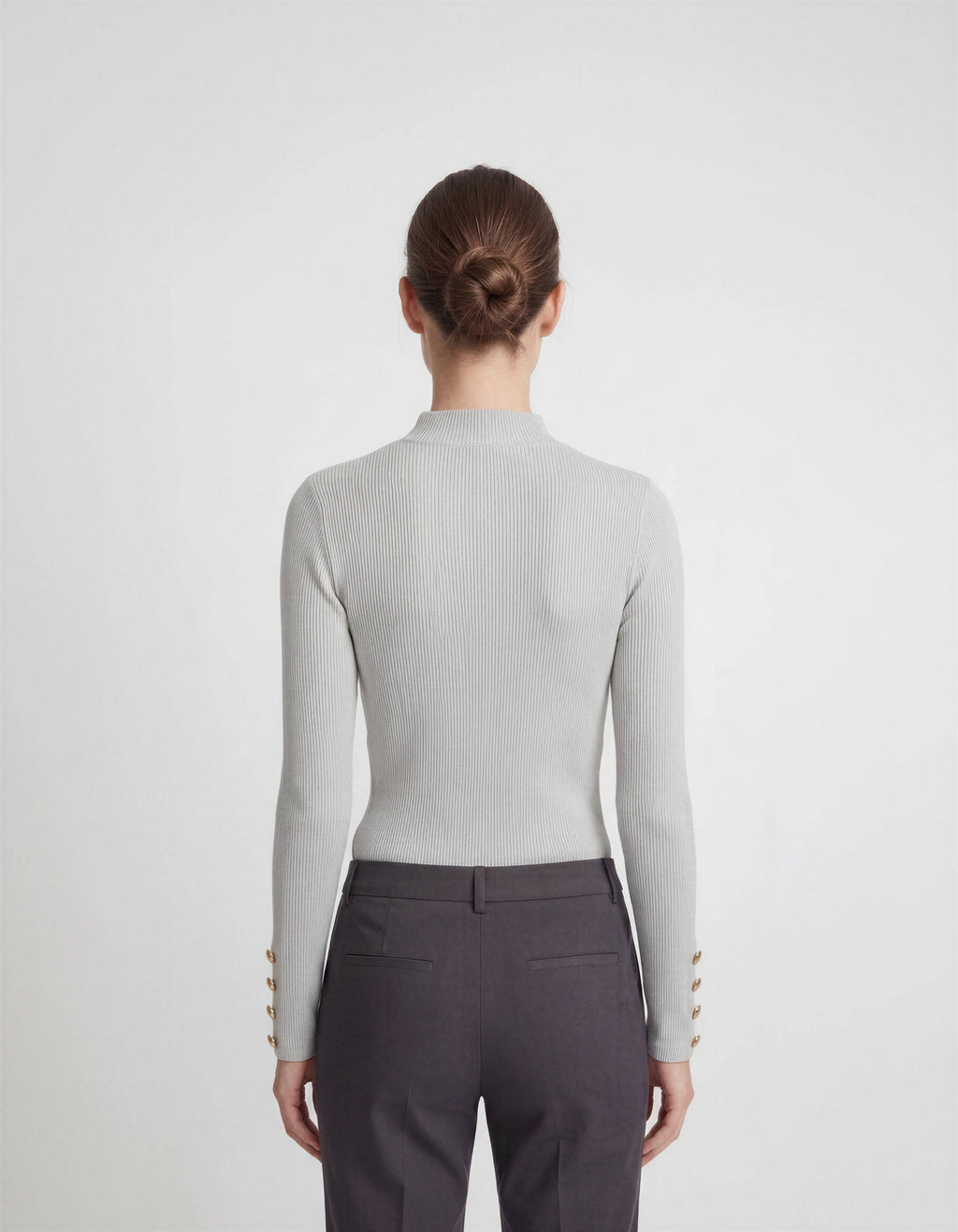 ROMAR ribbed mock neck top with gold button cuffs, showcasing a fitted knit design and stylish button details.