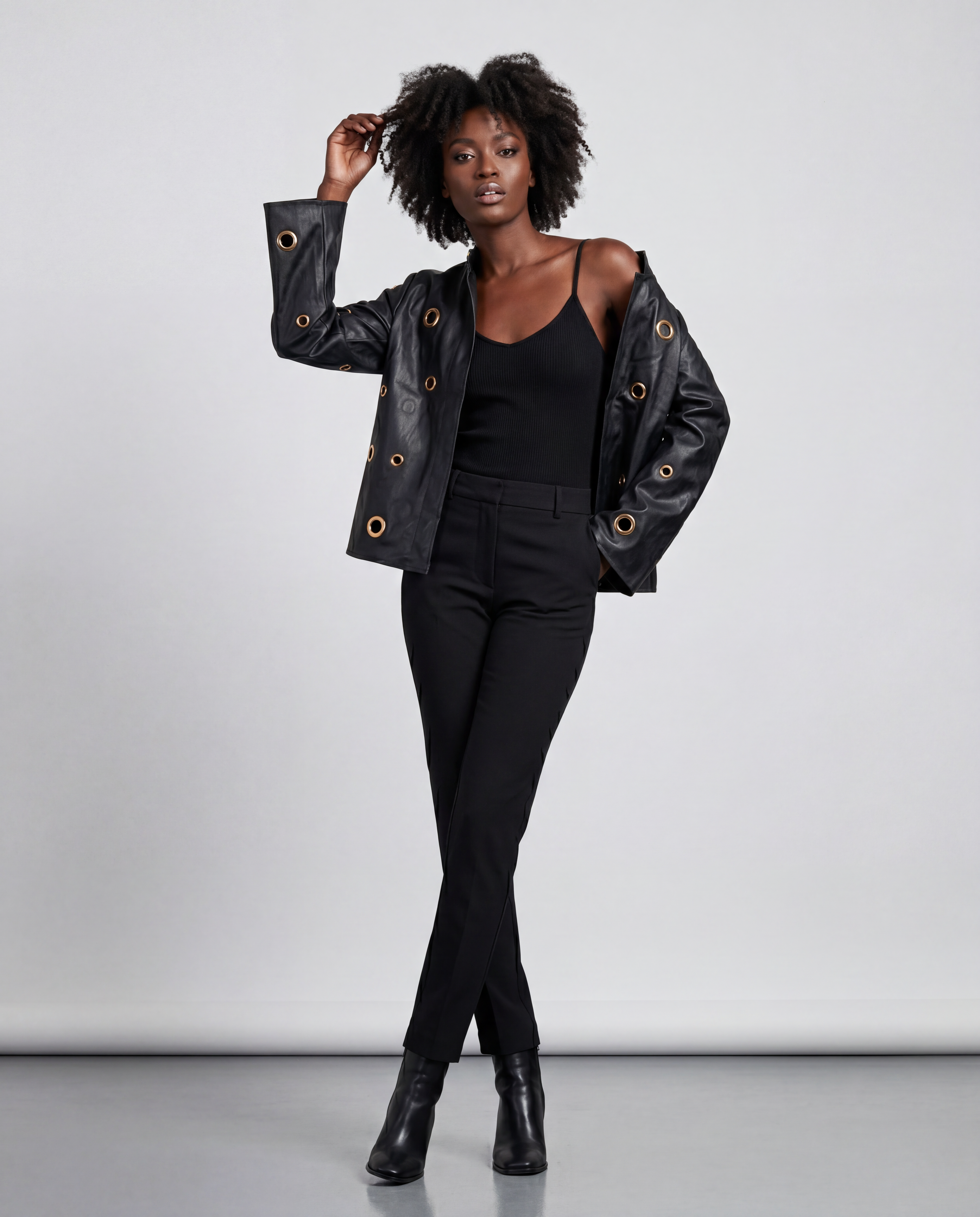 Gold eyelet embellished faux leather jacket by ROMAR, featuring stylish design and metal eyelet details on the jacket front.