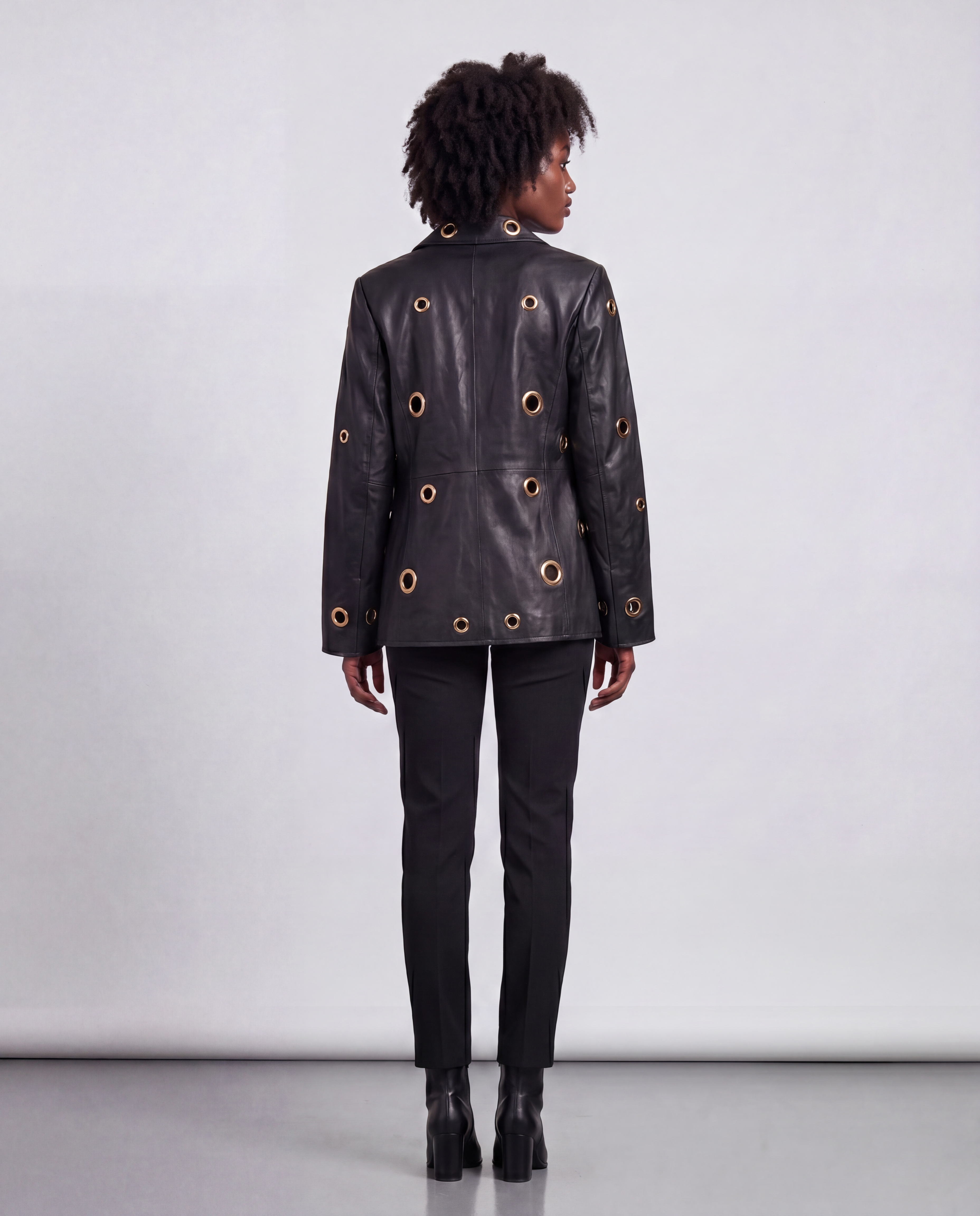 Gold eyelet embellished faux leather jacket by ROMAR, featuring stylish eyelet details and a sleek leather look.