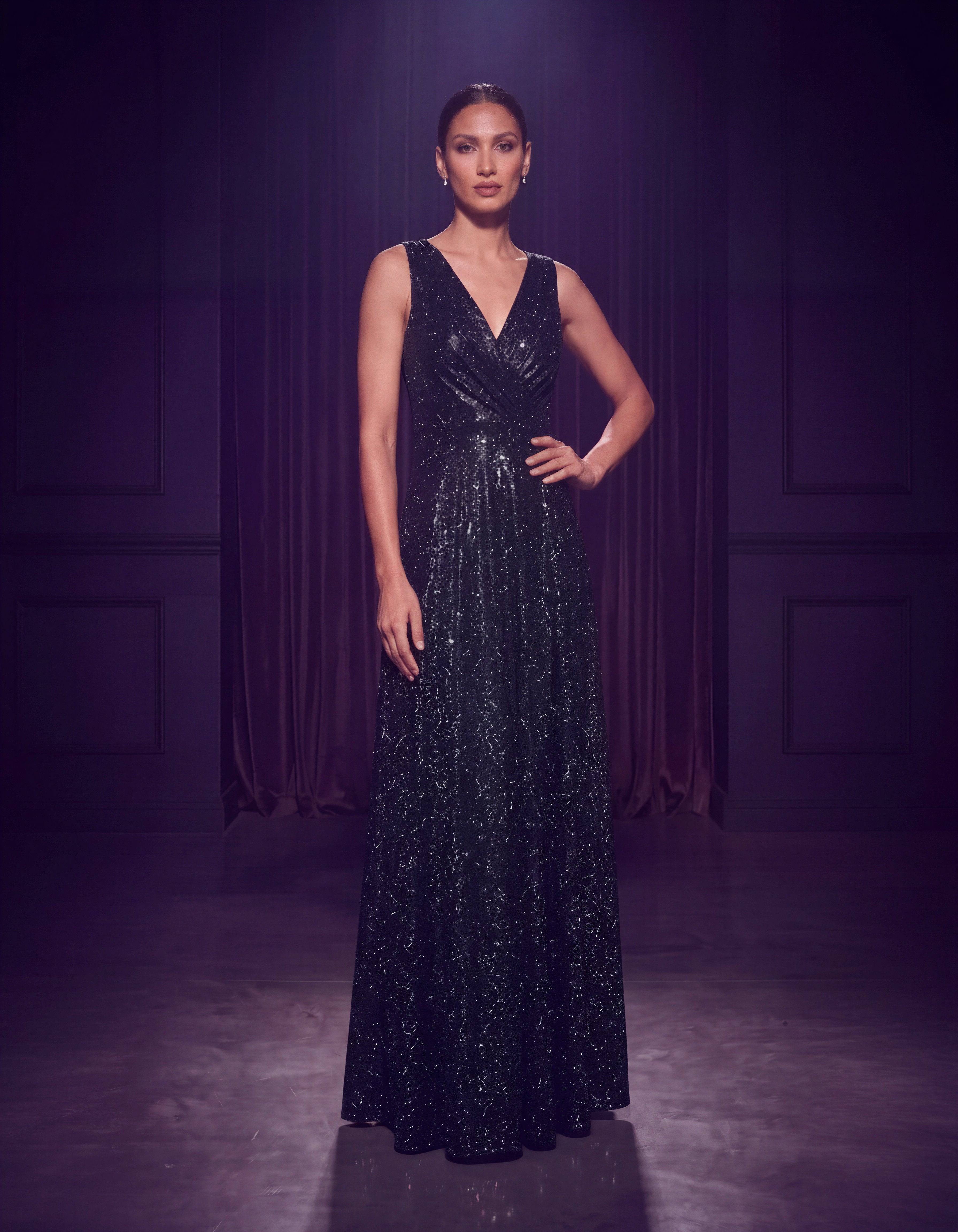 ROMAR glitter wrap V-neck sleeveless prom maxi dress displayed on a hanger with shimmering fabric and elegant design details.